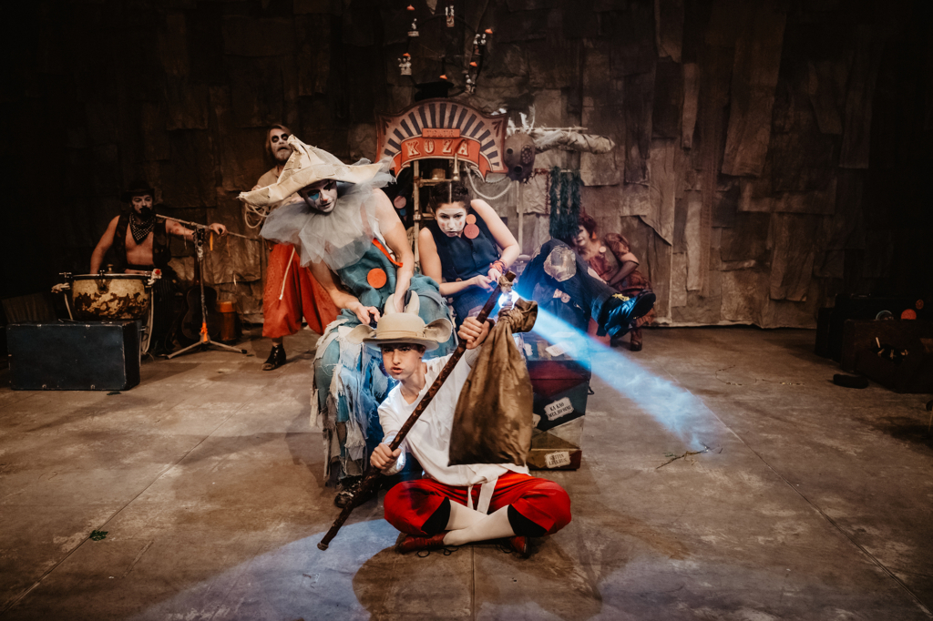 W centrum kompozycji znajduje się grupa kolorowych postaci, pochylona w prawo – całość sprawia wrażenie, jakby imitowali jazdę samochodem. Na pierwszym planie siedzi po turecku dziewczyna w białej koszuli i czerwonych spodniach. Na głowie ma biały kapelusz z przyczepionymi kozimi różkami. W ręku trzyma kij, który udaje kierownicę.